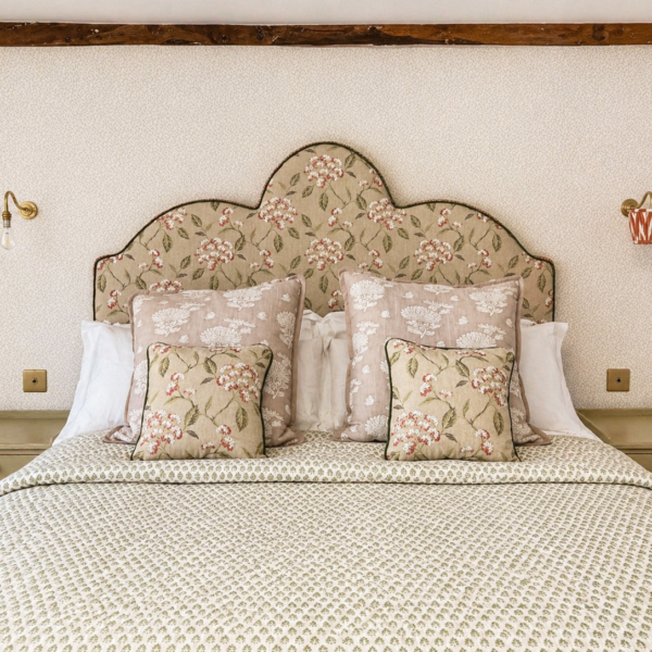 Bespoke floral upholstered headboard with matching cushions and contrast piping