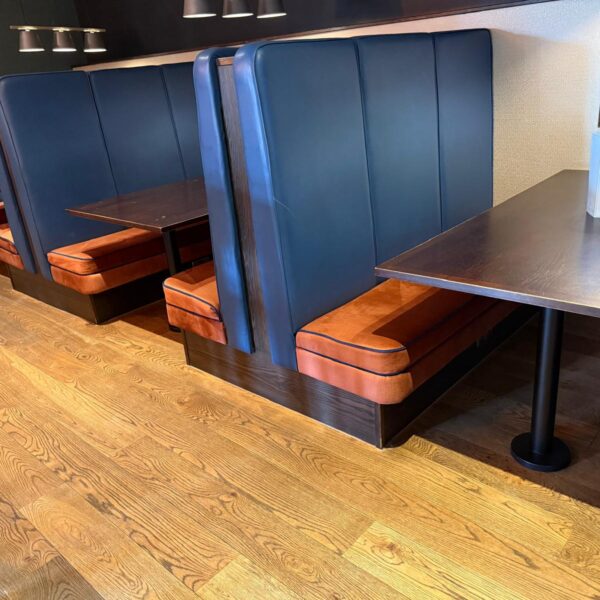 Commercial hotel bar booth seating reupholstery with burnt orange and navy blue banquette seating by Creature Comforts Upholstery